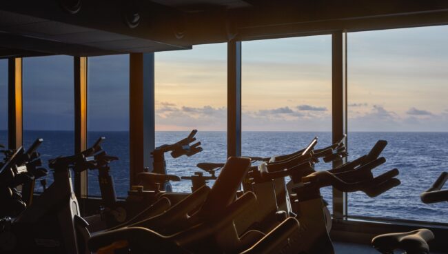 An exercise bike studio with a large window overlooking the ocean