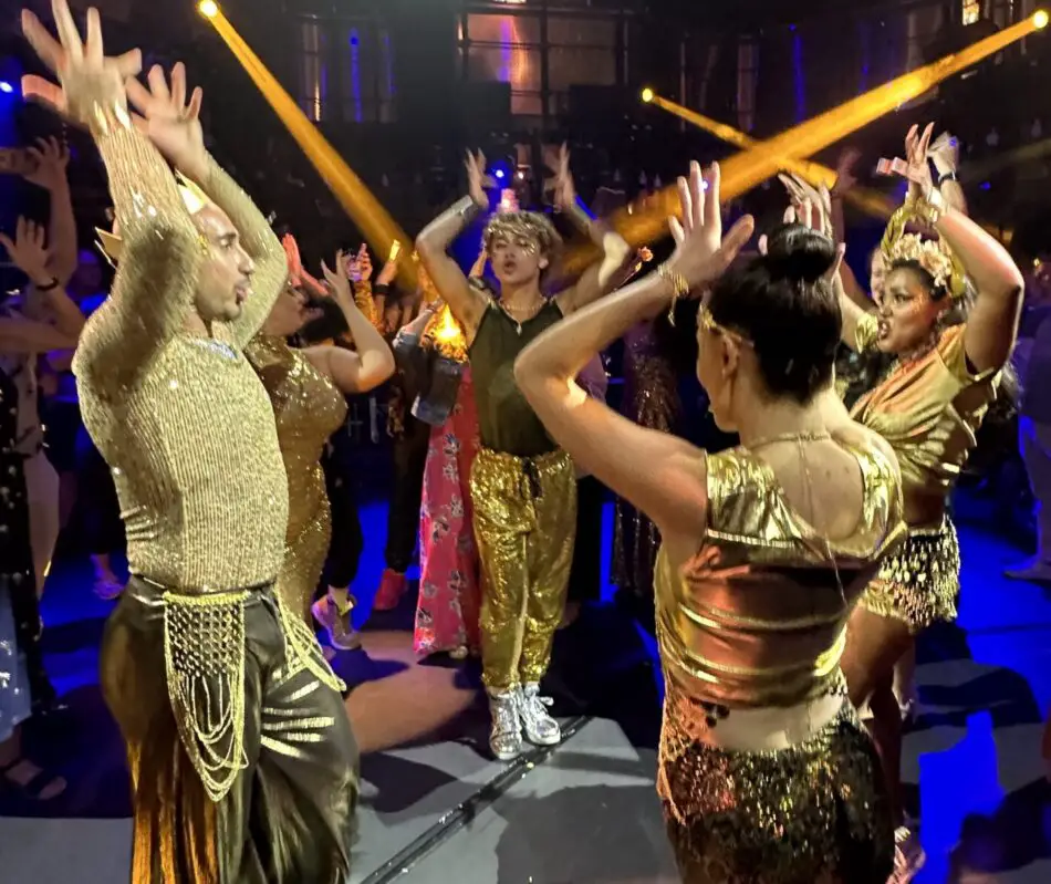 5 dancers in a circle dressed in gold