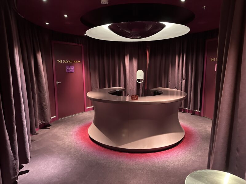 A room with a circular reception desk surrounded by curtained walls
