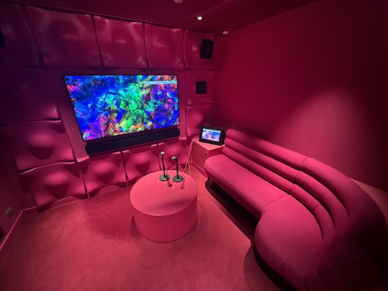 A private karaoke room with pink interior furnishings and lighting