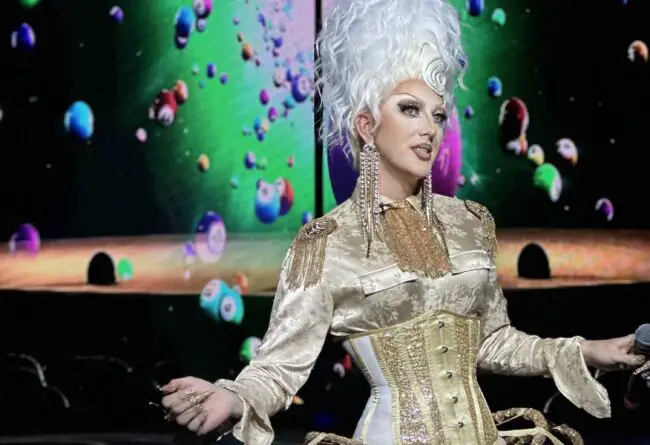 A drag queen in front of bingo balls