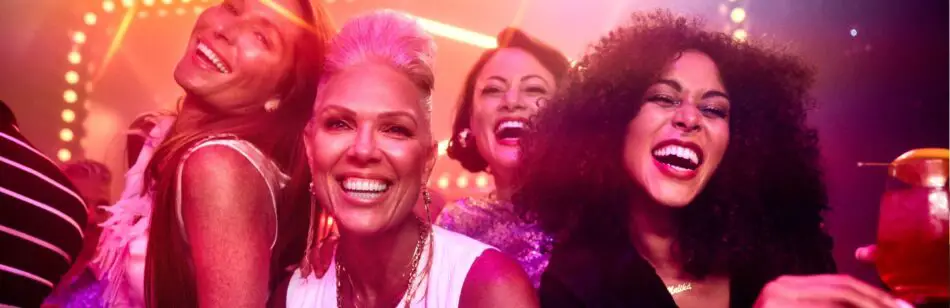 A group of people celebrating agains a pink glittering background