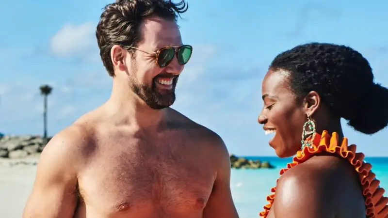 A couple smiling at each other against an idyllic beach background