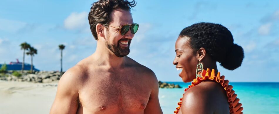 A couple smiling at each other against an idyllic beach background