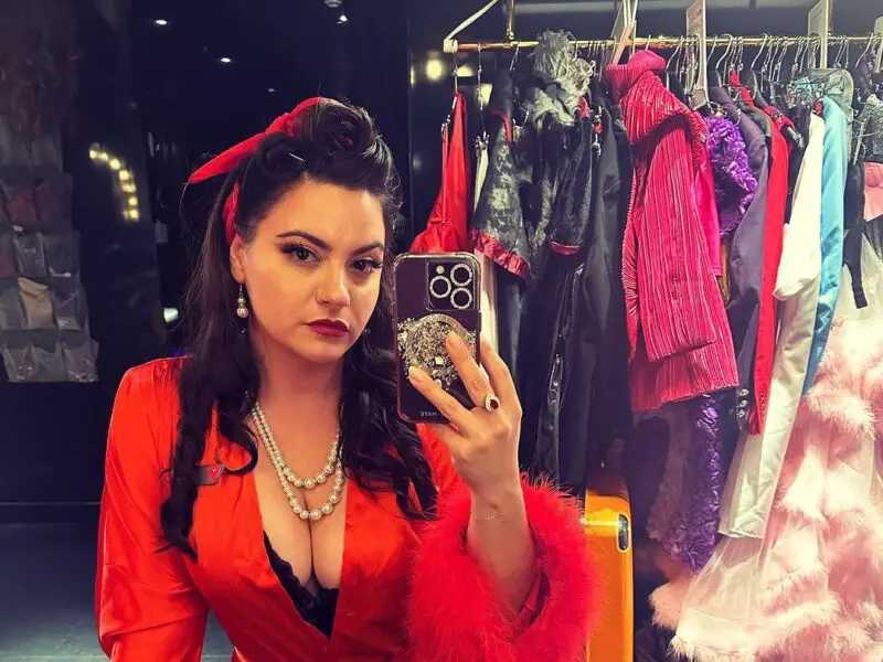 a person taking a mirror selfie wearing red clothing in a dressing room