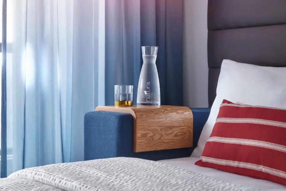 a bedside table with a glass decanter of water