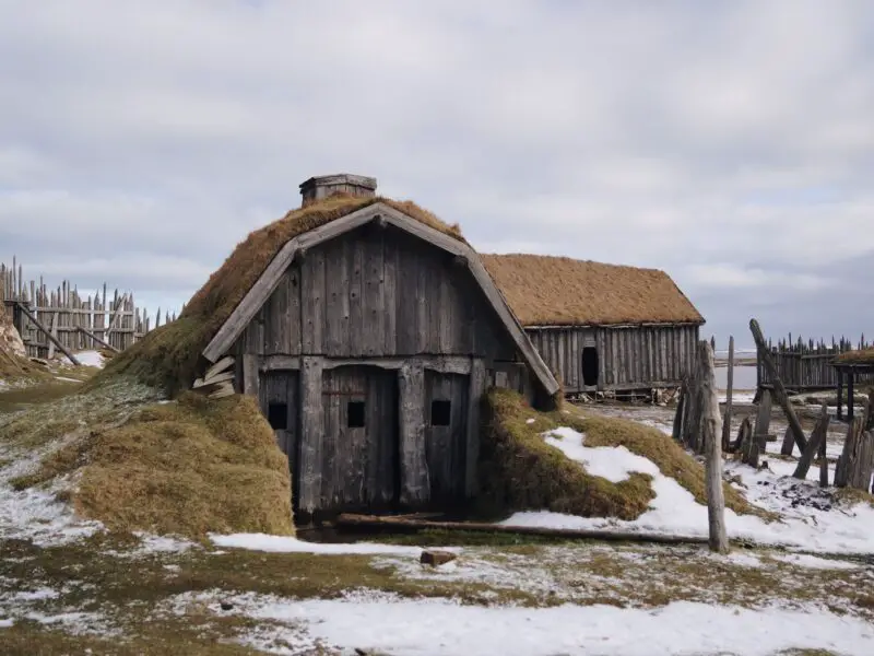 gray wooden house near sea under white skies