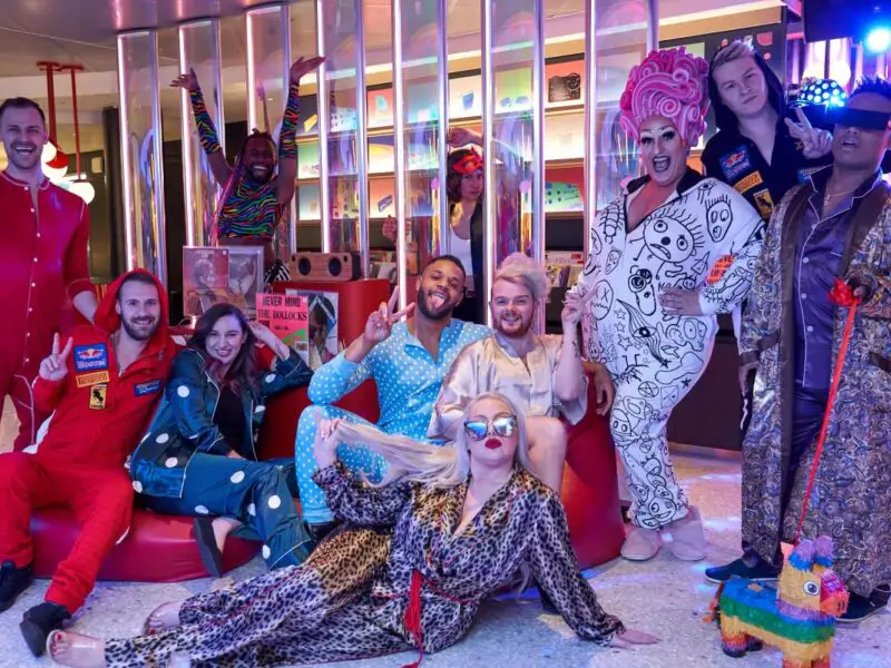 a group of people in fun pyjamas posing in a colourful room