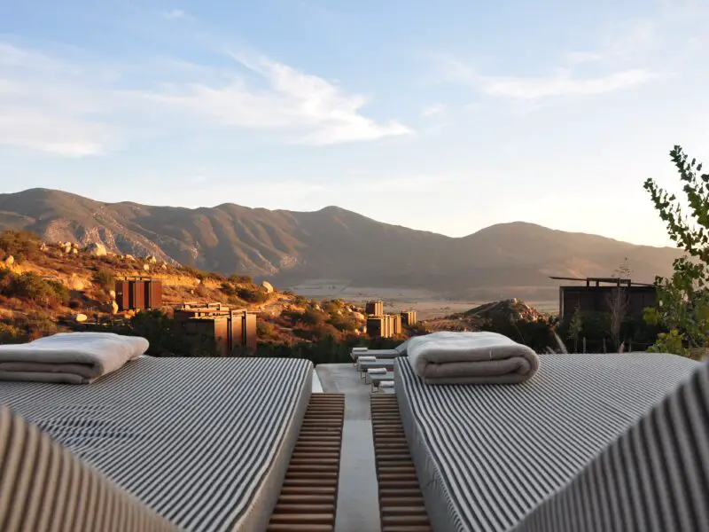 A group of pool chairs looking out to a mountain landscape