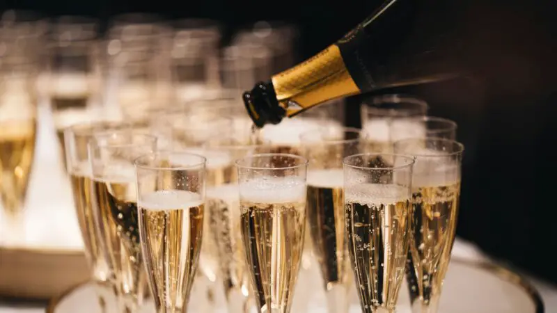 Champagne Flutes filled with champagne with a bottle pouring