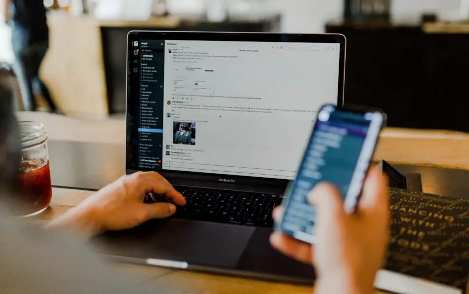 A person working on a laptop and phone using Wi-Fi