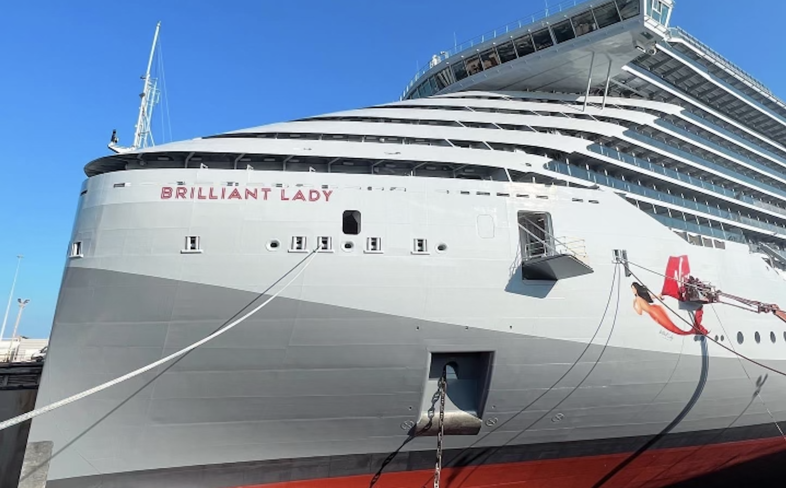 A mermaid being pained on the side of a cruise ship with 'Brilliant Lady' written underneath