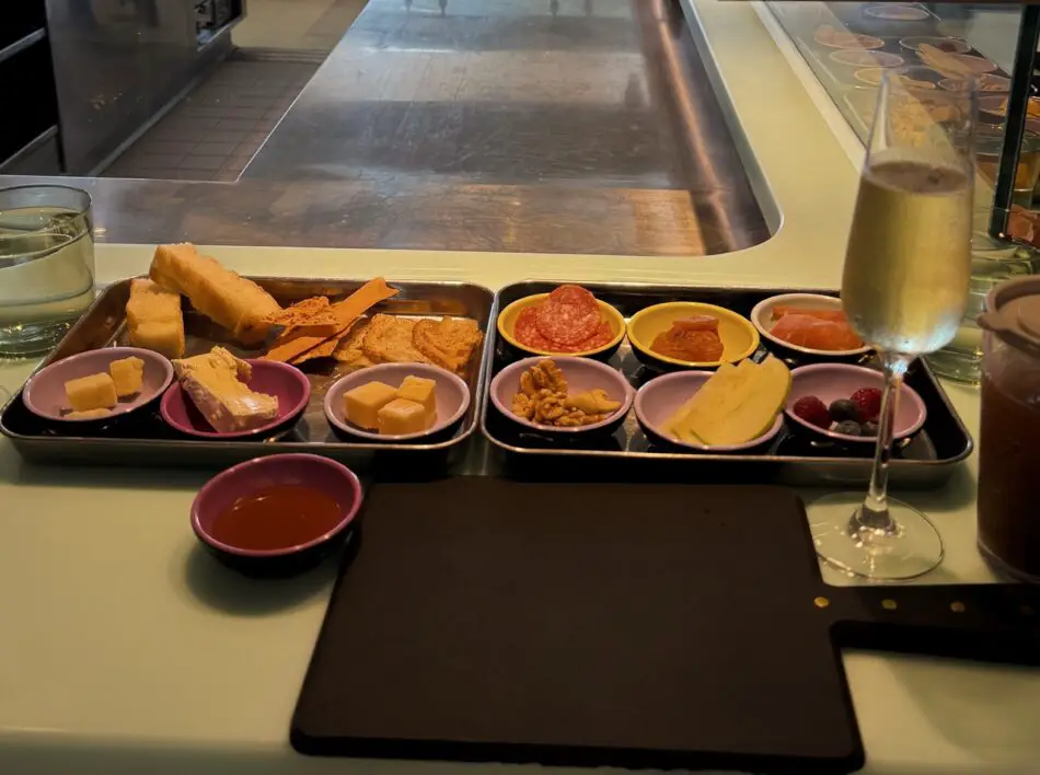 An assembled charcuterie board with sparkling wine