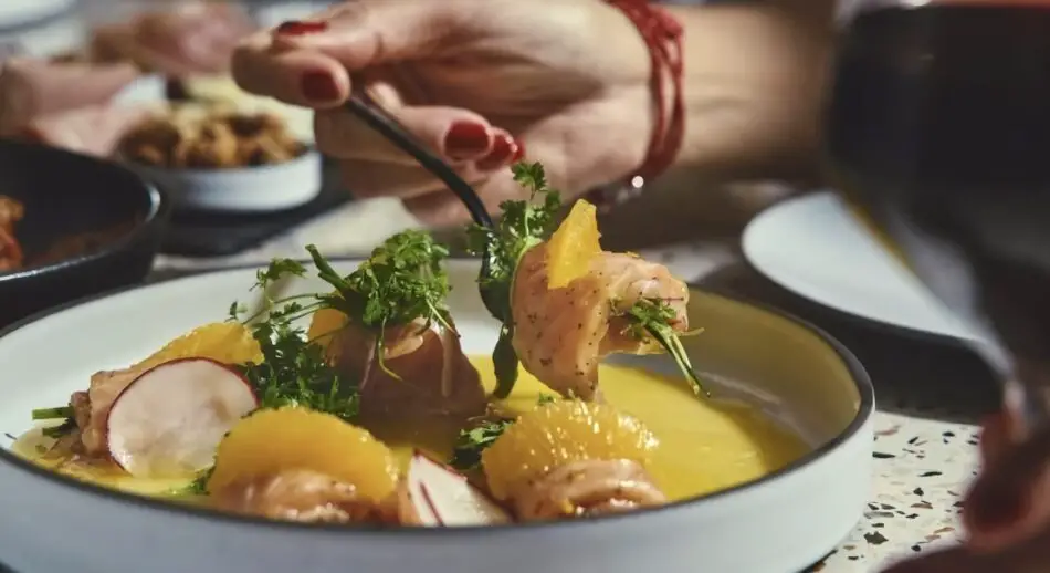 Salmon Crudo: A dish featuring radish, red onion, and mandarin sauce (GF) at Extra Virgin