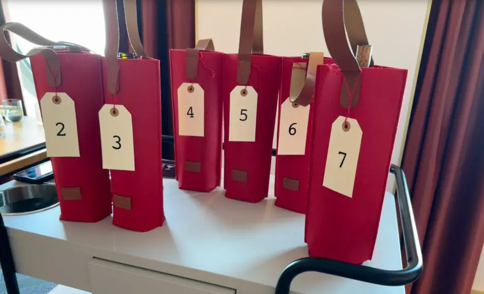 Red gift bags containing mystery bottles of wine, numbered 2 to 7