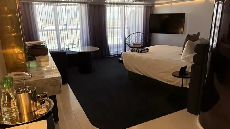 Virgin Voyages cruise ship cabin with bed and seating area