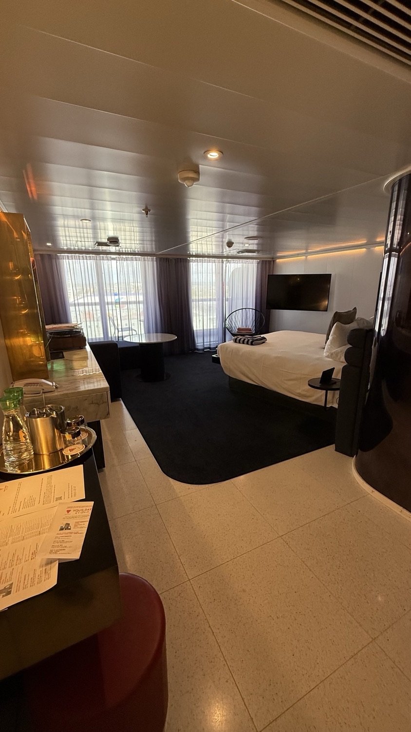 Virgin Voyages cruise ship cabin with bed and seating area