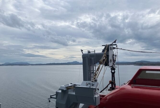 Red lifeboat on the deck with rigging aboard a Virgin Voyages cruise ship
