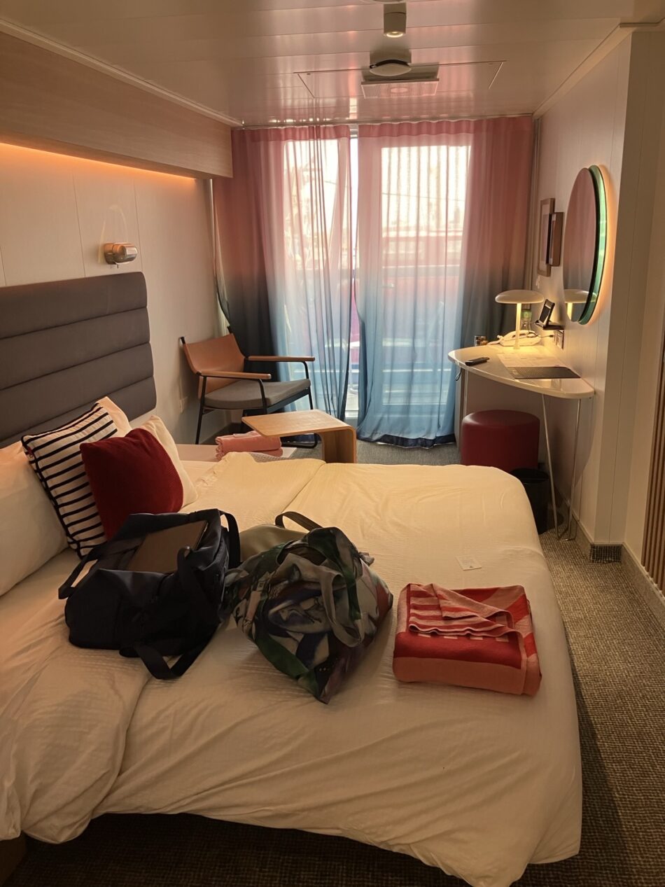 Virgin Voyages cruise ship cabin with bed and workspace