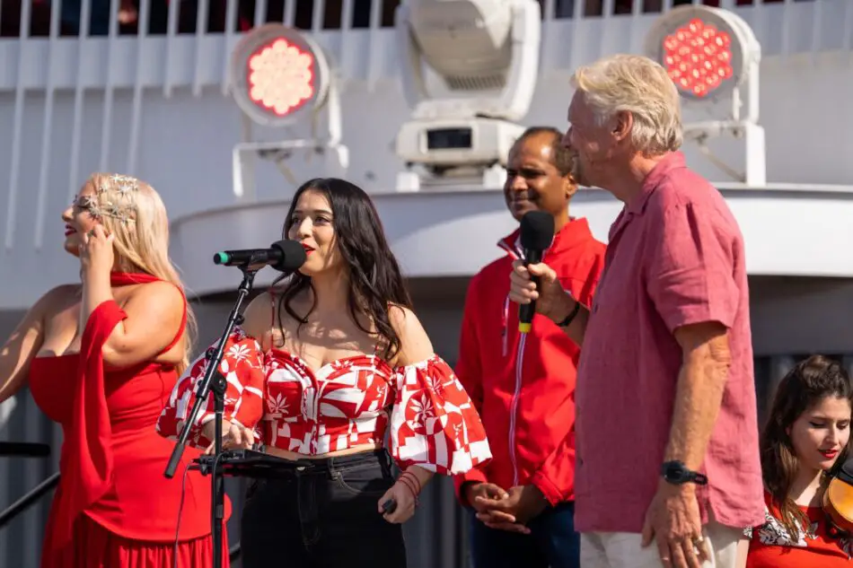 Female singer performing on a shipboard stage with backup singers