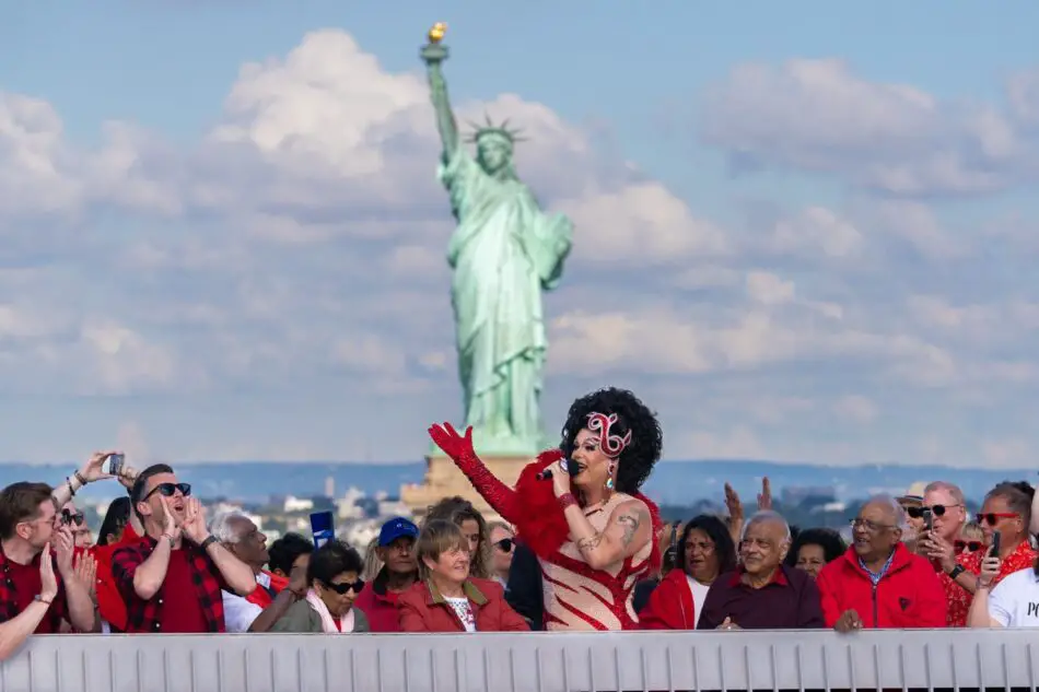 Drag queen performs on a cruise ship deck with the Statue of Liberty in the background