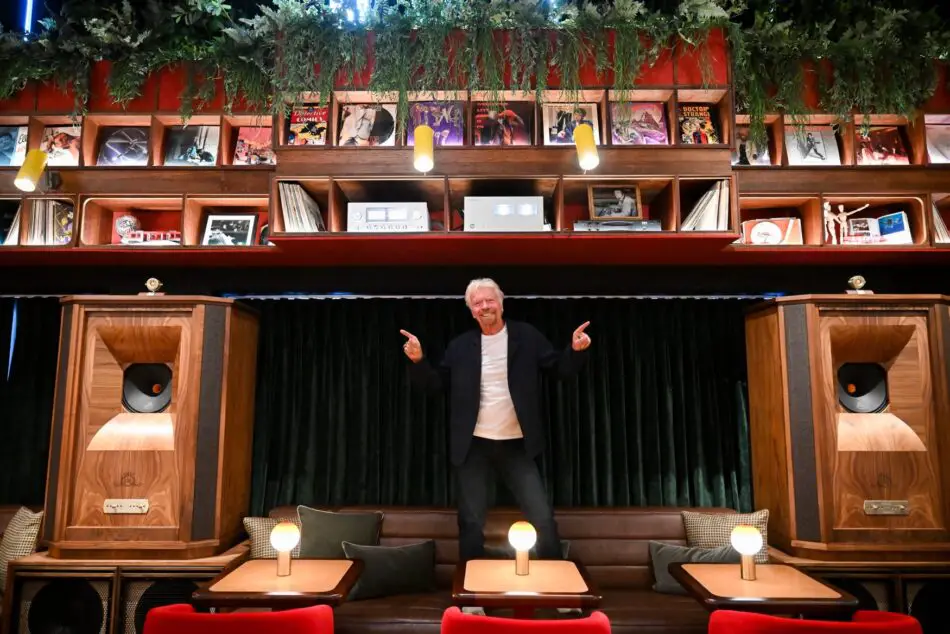 Richard Branson in a retro lounge, Hidden Grooves, with large wooden speakers and vinyl records