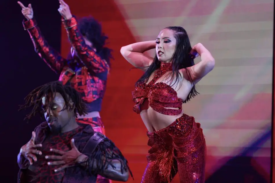 Two dancers in red sequined outfits perform on stage