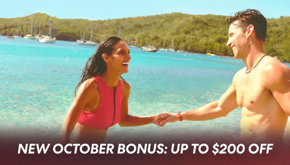 Two people on a tropical beach by turquoise sea, smiling and holding hands