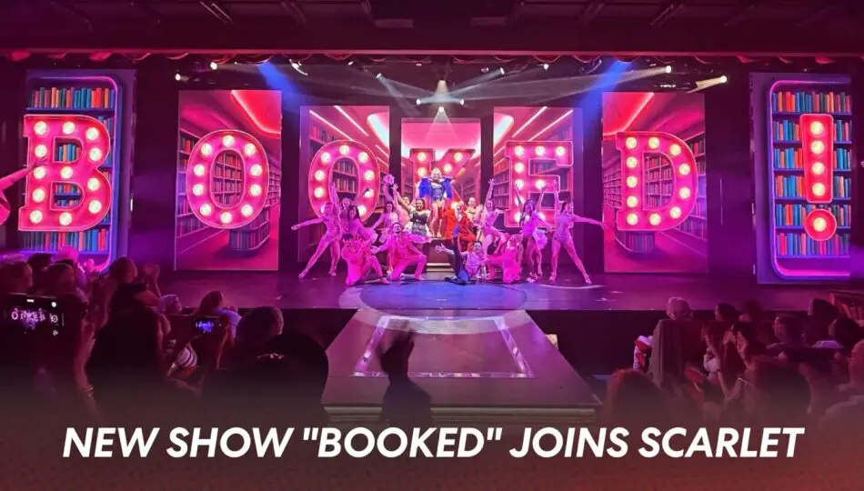 Stage performance with pink-clad dancers and large illuminated BOOKED letters on the backdrop