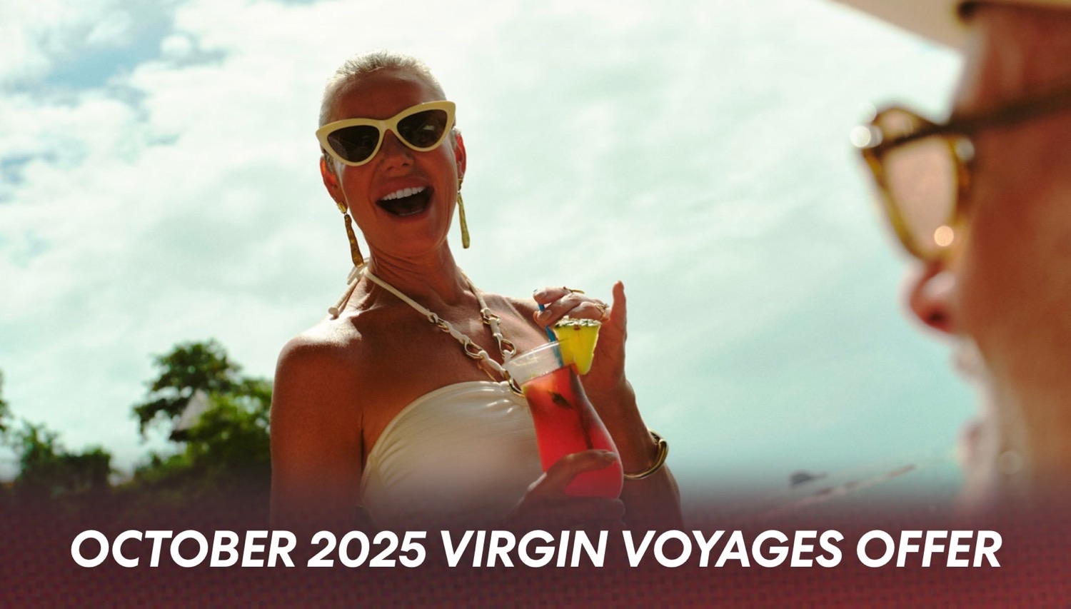 Two women in white outfits enjoy tropical drinks on a Virgin Voyages cruise ship deck