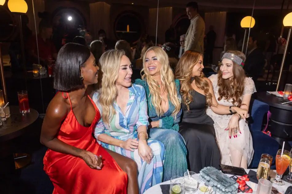 Five women in stylish outfits sit together in a Virgin Voyages cruise ship lounge