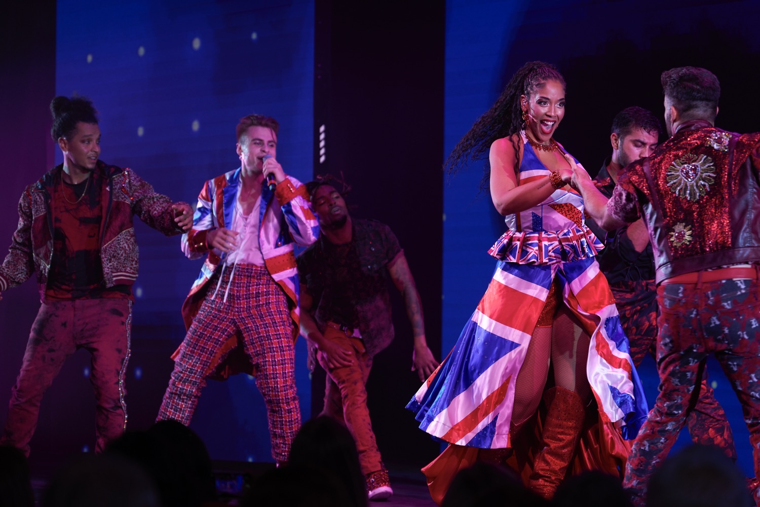 Performers in Union Jack themed outfits perform on a Virgin Voyages cruise ship