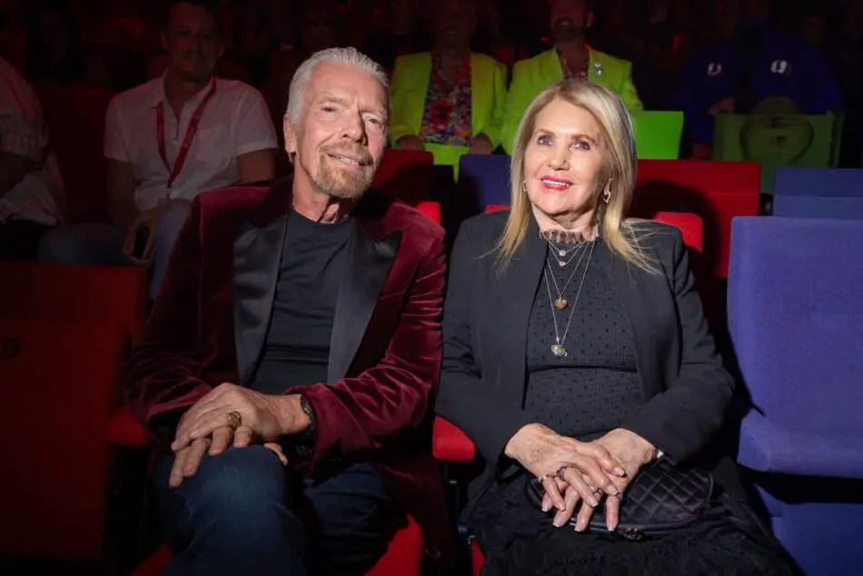 Smiling older couple holding hands in a colorful theater audience
