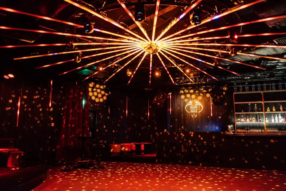 Nightclub interior with a large starburst chandelier and a bar, Blue Marlin Ibiza signage