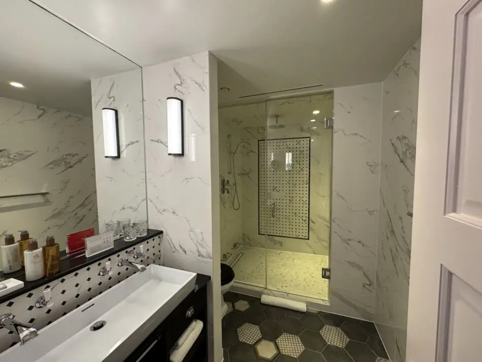 Luxurious marble bathroom in a suite in Virgin Hotels London Shoreditch with a double vanity and glass shower