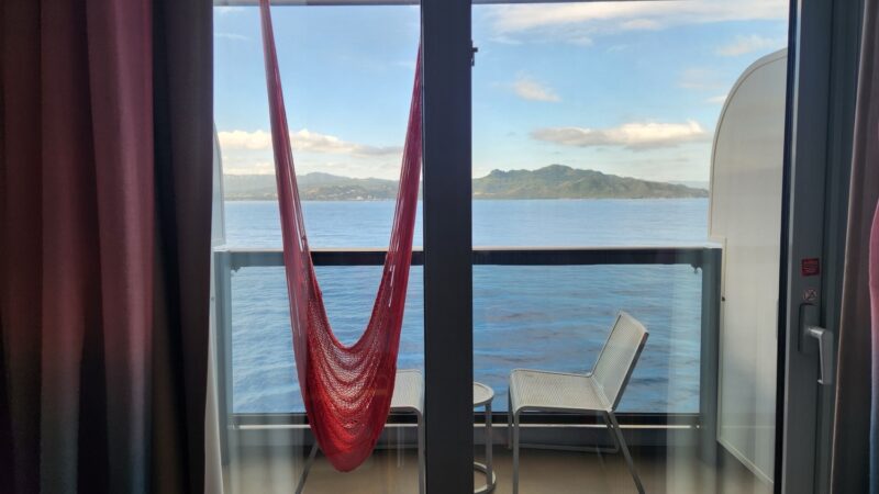 Virgin Voyages cabin balcony with a red hammock and ocean view
