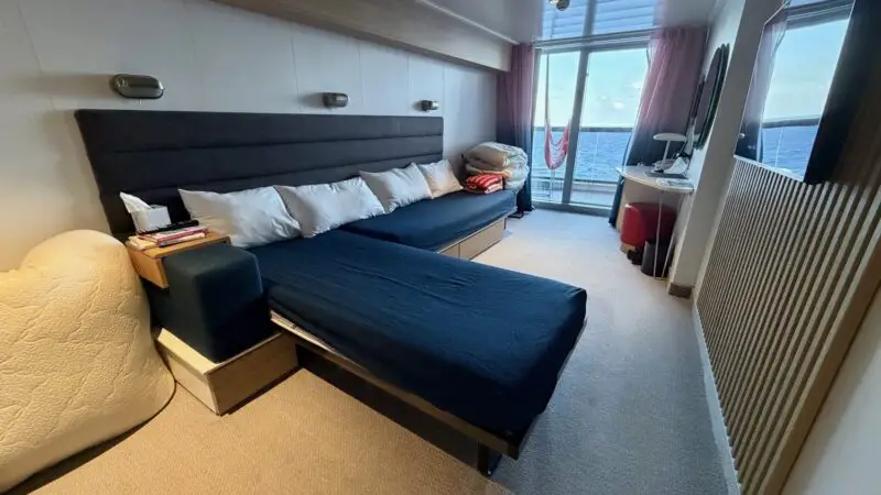 Virgin Voyages cruise cabin with navy bed and sea view