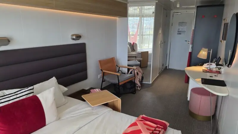 Virgin Voyages cruise ship cabin with bed and workspace