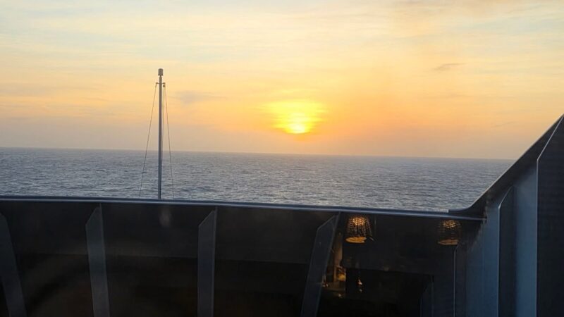 Sunset over the sea from a Virgin Voyages cruise ship balcony