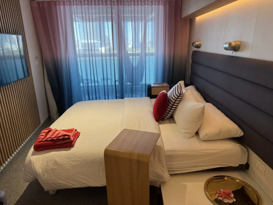 Hotel-style cruise ship cabin with balcony on a Virgin Voyages ship