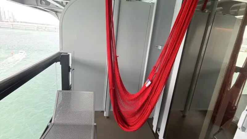 Red hammock hangs in a Virgin Voyages balcony cabin
