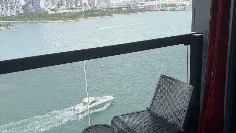 Balcony seating on a Virgin Voyages cruise ship overlooking the city skyline