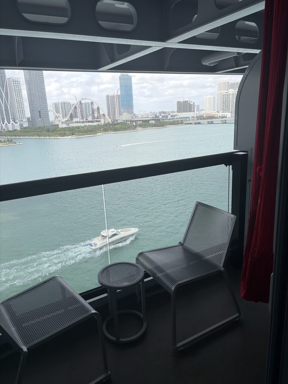 Balcony seating on a Virgin Voyages cruise ship overlooking the city skyline