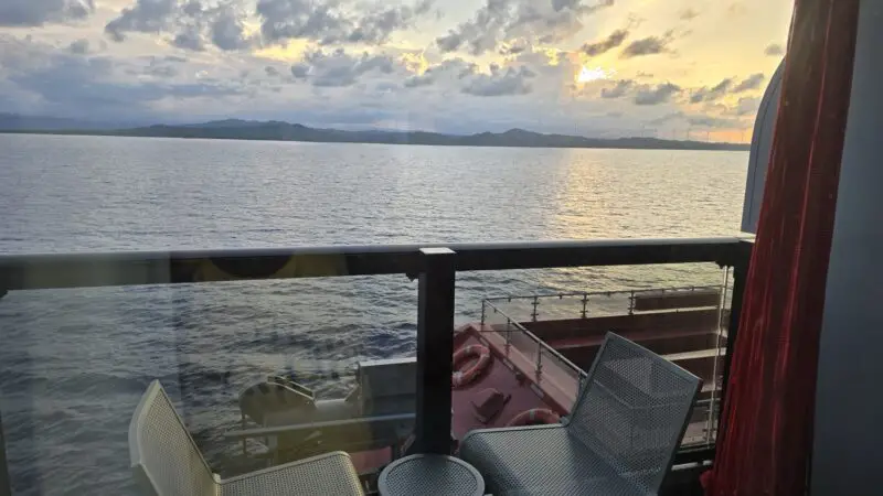 Balcony on a Virgin Voyages cruise ship overlooking the sea at sunset