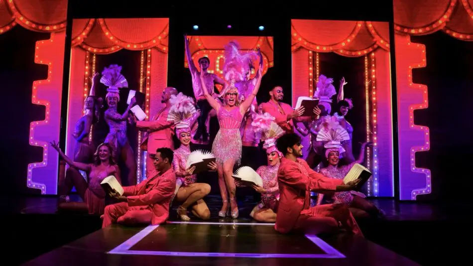 Stage show with dancers in pink outfits and feathered headpieces