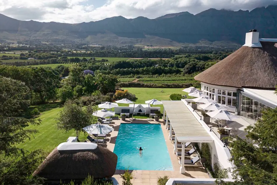Resort pool area with white umbrellas, thatched roof buildings, and Mountain View's