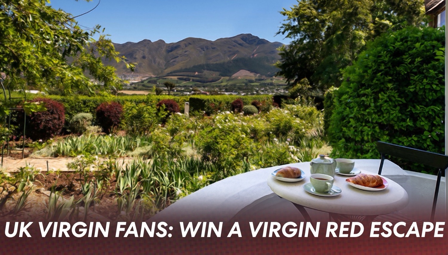 Outdoor garden terrace with a round table set for breakfast, croissants and tea, mountains in the background