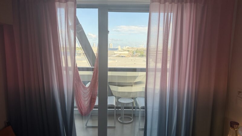 Virgin Voyages cabin with balcony, pink gradient curtains and hammock