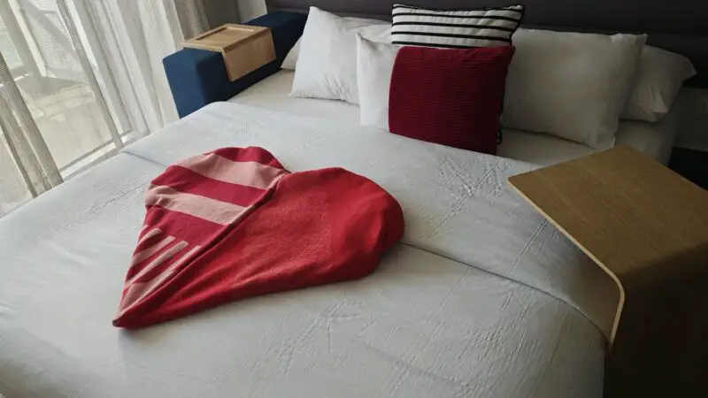 Virgin Voyages cruise ship cabin bed with a red towel heart