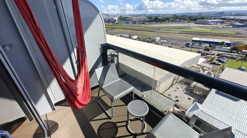 Balcony on a Virgin Voyages cruise ship cabin with red hammock chair